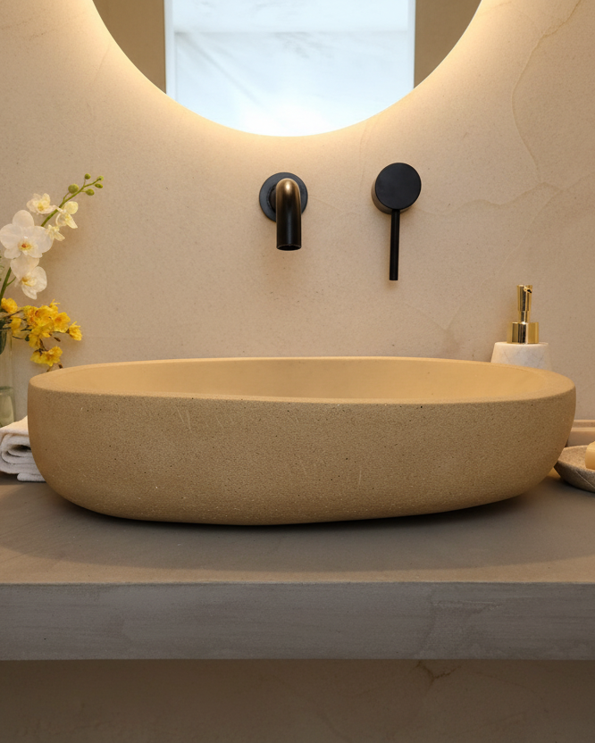 Beige concrete sink in organic pill shape in a soft tone bathroom
