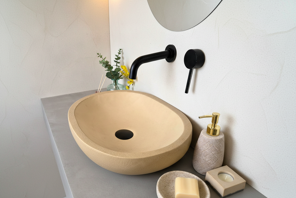 Beige sink on a bathroom counter with black faucet and decorative elements.