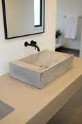 Rectagular concrete basin, surfacce mounted with wave-like bowl interior