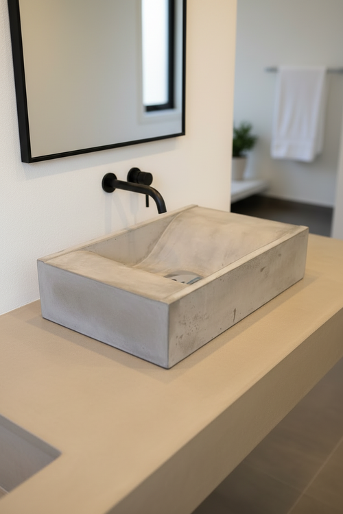 Rectagular concrete basin, surfacce mounted with wave-like bowl interior