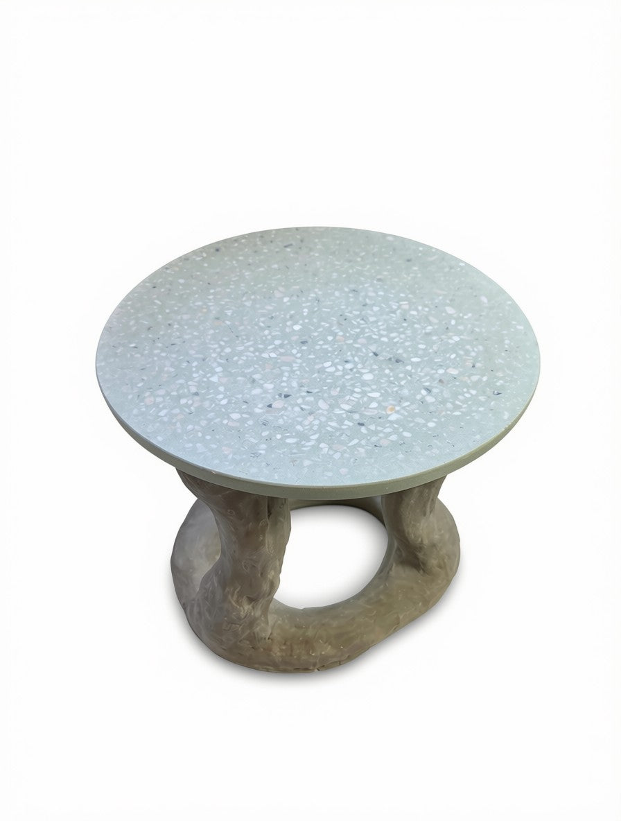 A round concrete coffee table with an exposed aggregate concrete light gray top and a sculptural, organic-shaped concrete base, shown on a plain white background.
