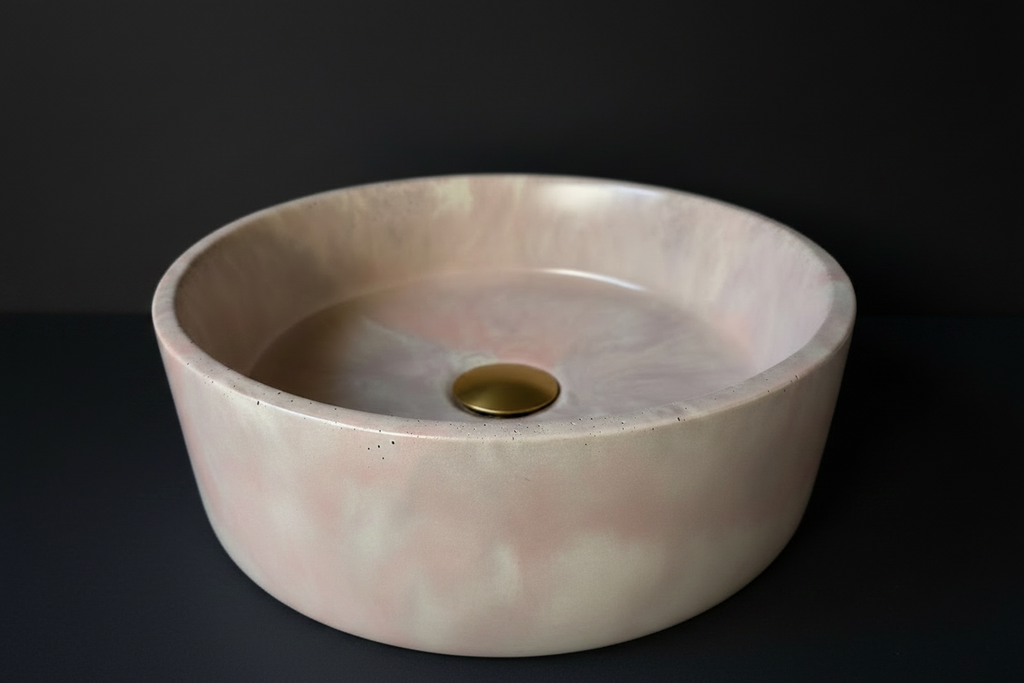 front view of LAI round concrete basin, part of the marbeli collection, with soft flowing colour variation in pink, ivory and soft brown tones.