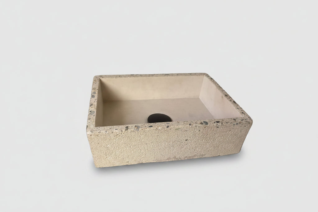 Concrete sink with exposed aggregate edge and rough exterior on white background