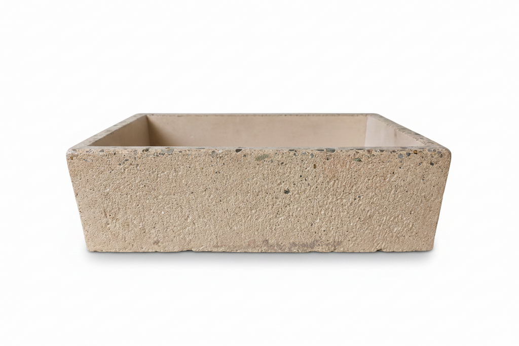 Rectangular concrete sink with rough  exterior finish and polished edge on a white background