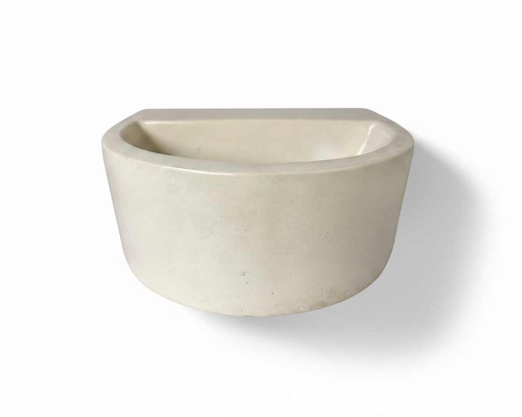 A minimalist, semi-circular concrete vessel with a matte off-white finish, shown against a plain white background with a soft shadow.