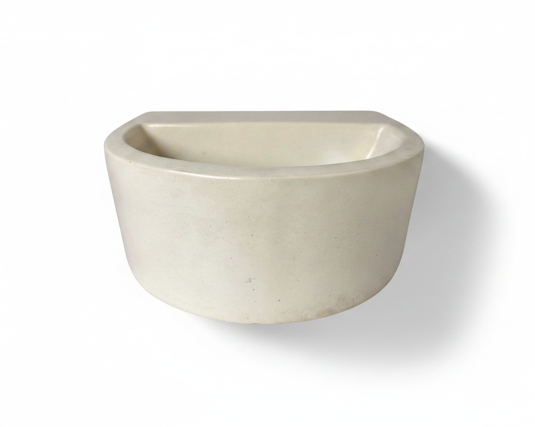 A minimalist, semi-circular concrete vessel with a matte off-white finish, shown against a plain white background with a soft shadow.