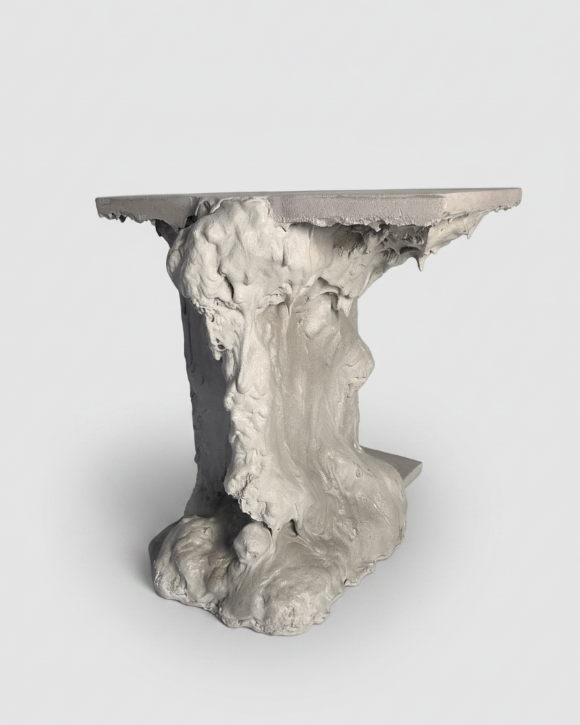 A sculptural side table with a flat rectangular top and a highly textured, organic base resembling weathered stone or tree trunk, shown on a light gray background.