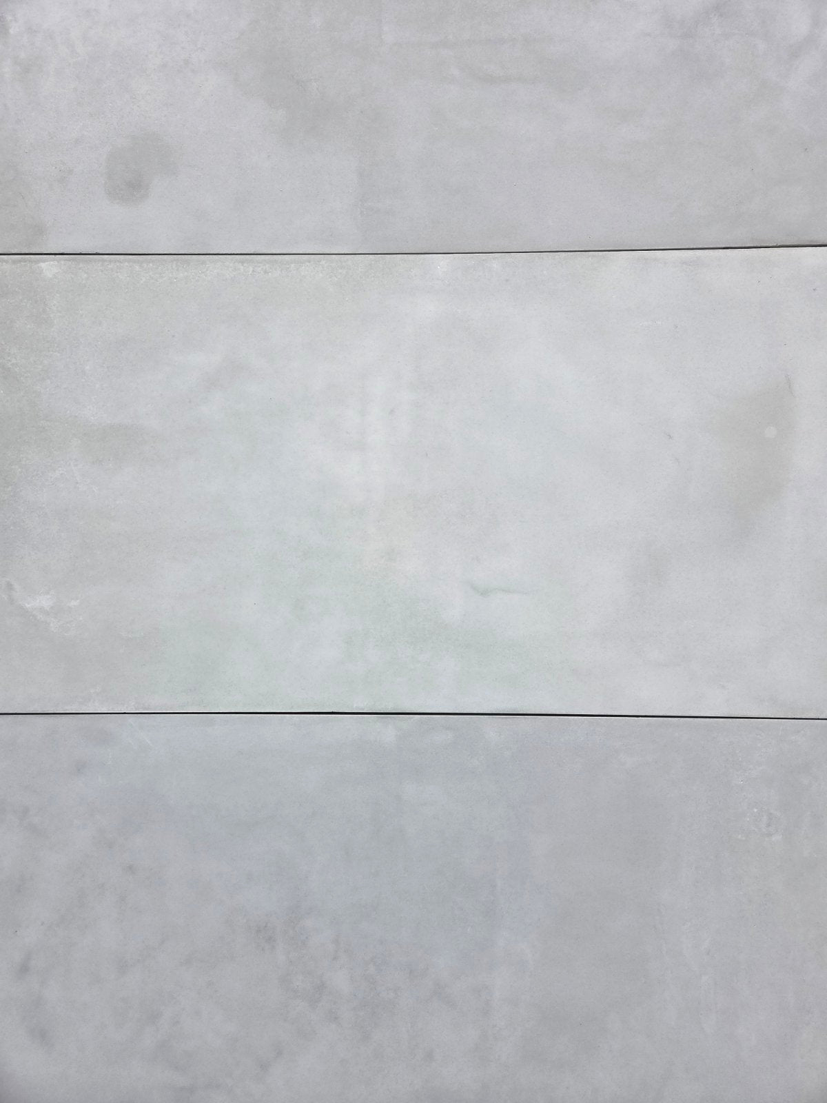 Three horizontal rectangular concrete panels in a light gray concrete finish, arranged side by side with thin grout lines.
