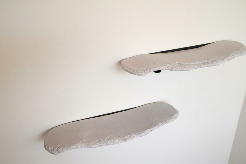 Handcrafted concrete shelf with raw textured edge and black steel bracket