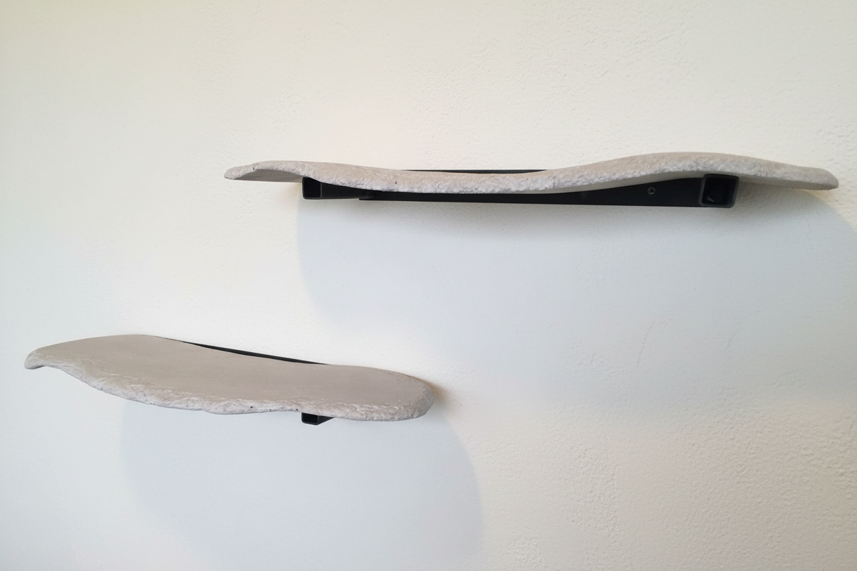 Two concrete shelves arranged asymmetrically on a white wall