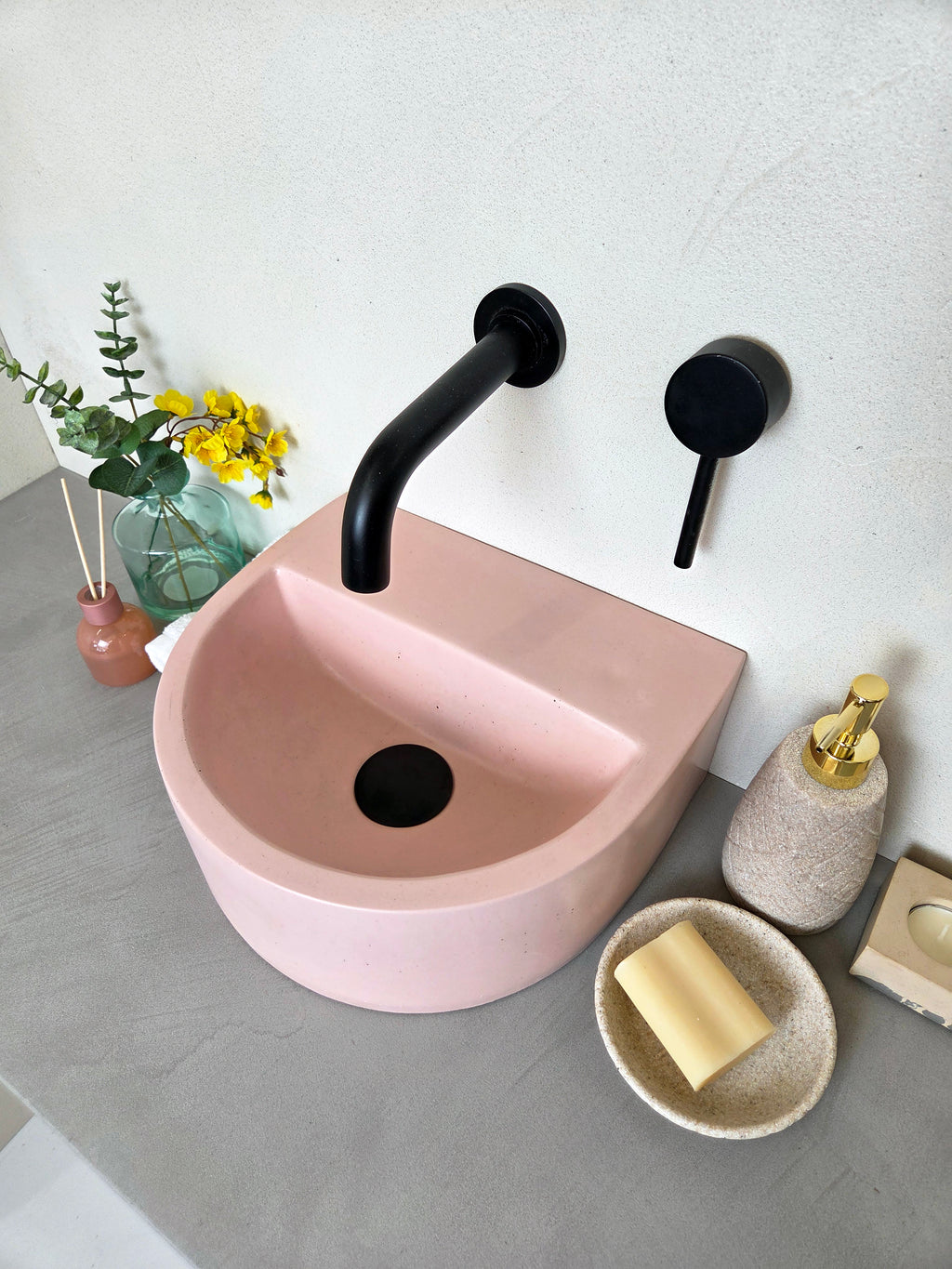 Compact concrete vanity basin with semi-circular shape and integrated shelf detail