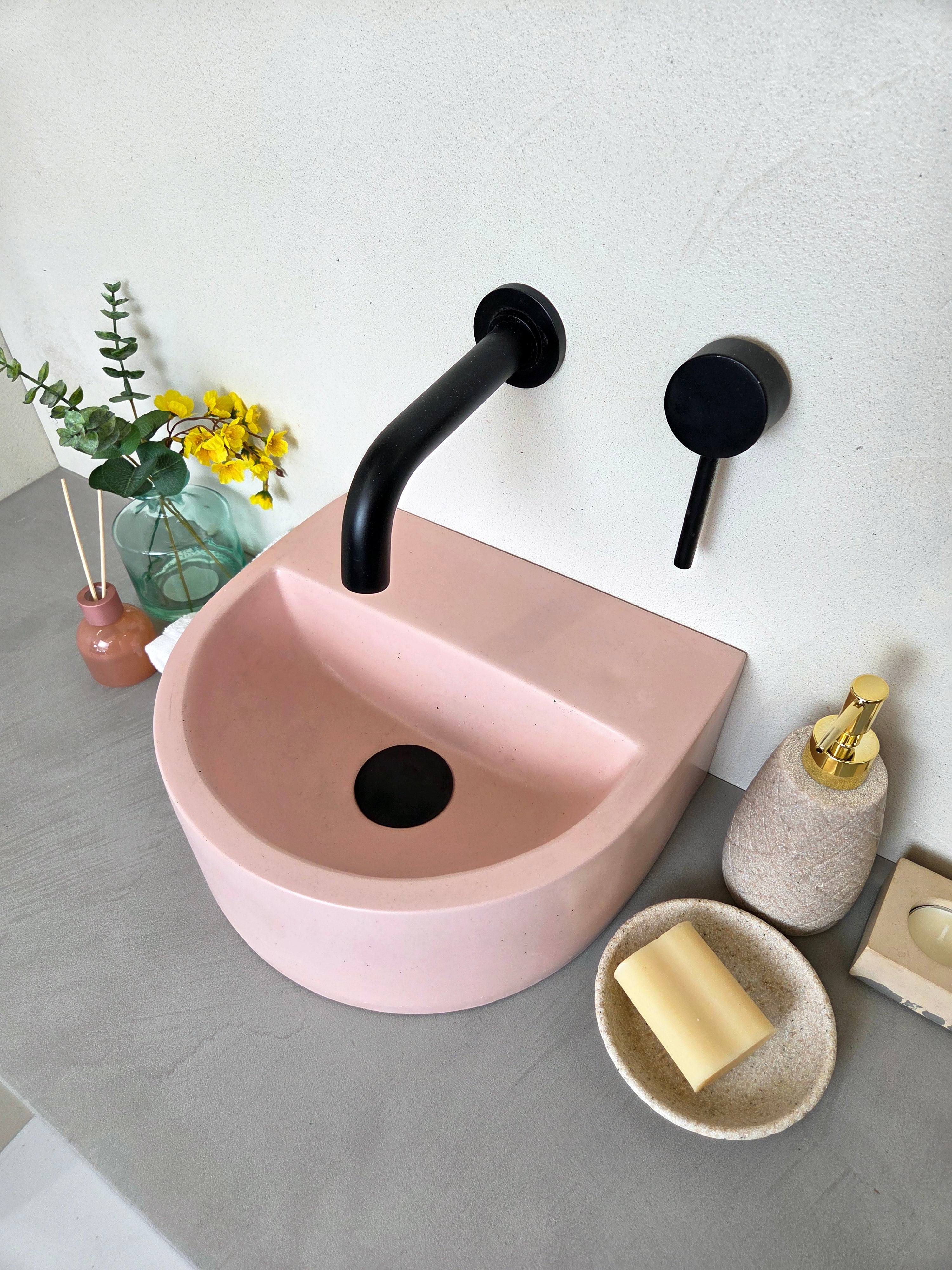 Compact concrete vanity basin with semi-circular shape and integrated shelf detail