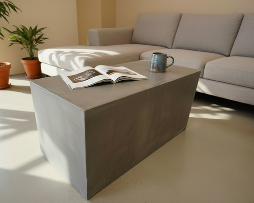 Grey rectangular microcement coffee table in a modern living room, styled to highlight its minimalist block design.
