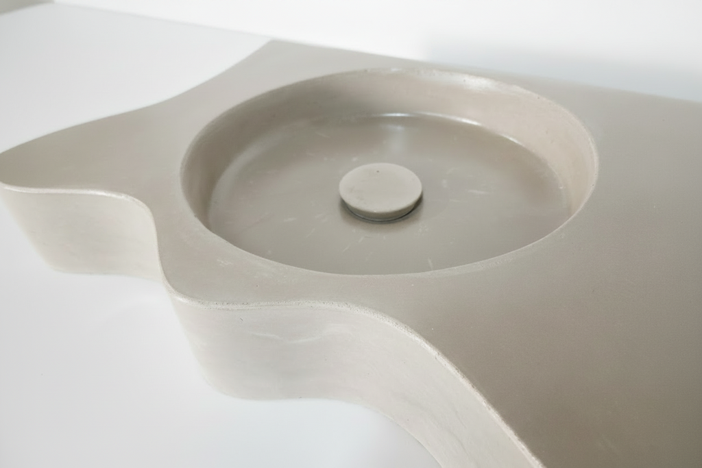 close up of concrete vanity sink modern wavy design with concrete waste cover by nedevdesign