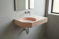 piink concrete sink wall mounted in a minimal modern bathroom